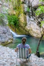 A dreamy girl is meditating in a lagoon near a waterfall. Royalty Free Stock Photo