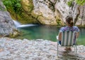 A dreamy girl is meditating in a lagoon near a waterfall. Royalty Free Stock Photo