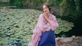 Dreamy girl posing lake covered water lilies closeup. Fantasy model sitting pond Royalty Free Stock Photo
