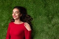 Dreamy girl in red dress lying on green grass Royalty Free Stock Photo