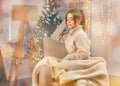 Dreamy girl in white sweater backdrop of a beautifully decorated Christmas lights bokeh background