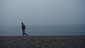 Dreamy guy looking sea view in foggy morning. Upset man standing on sandy beach Royalty Free Stock Photo