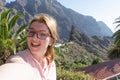 Dreamy lady with glasses smiling and taking selfie in her journey. Touristic alone woman laughing, enjoying and having fun in