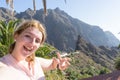 Dreamy lady making peace gesture with fingers, smiling and taking selfie in her journey. Touristic alone woman laughing, enjoying Royalty Free Stock Photo