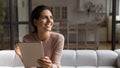 Dreamy latin woman work on tablet online look at distance
