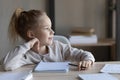 Dreamy little girl distracted from studying at home Royalty Free Stock Photo