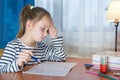 Dreamy little girl sit at desk studying look in distance visualizing or thinking, small child dreamer feel unmotivated distracted