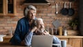 Dreamy mature couple hugging, looking to aside, using laptop together Royalty Free Stock Photo