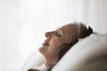 Dreamy middle-aged woman in headphones relaxing on sofa Royalty Free Stock Photo