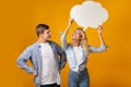 Dreamy millennial girl holding speech bubble above her head