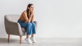 Dreamy millennial woman looking at blank space with pensive facial expression against white studio wall, panorama