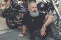 Dreamy old man locating near motorcycle