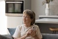 Dreamy old middle aged woman in eyeglasses holding cellphone. Royalty Free Stock Photo