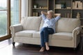 Dreamy positive mature woman relaxing on home sofa Royalty Free Stock Photo