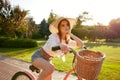 Dreamy romantic teenager girl riding bicycle in summer park