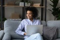 Dreamy smiling African American woman holding laptop, looking in distance Royalty Free Stock Photo