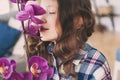 dreamy smiling kid girl smells orchid flower