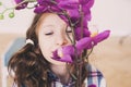 smiling kid girl smells orchid flower at home