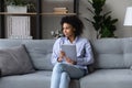 Dreamy thoughtful African American woman looking in distance, holding tablet Royalty Free Stock Photo