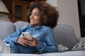 Dreamy thoughtful gen Z teen Black girl resting on couch Royalty Free Stock Photo