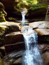 Dreamy waterfall in forest with dappled sunlight through trees