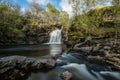 Dreamy waterfall and river in sunny woodlands Royalty Free Stock Photo