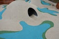 Dreamy white rubber landscape with scoops and colorful spots on the playground. stainless steel tunnel through the wave. design co