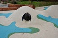 Dreamy white rubber landscape with scoops and colorful spots on the playground. stainless steel tunnel through the wave. design co