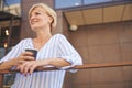 Dreamy woman with coffee and a smartphone Royalty Free Stock Photo