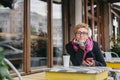 Dreamy woman with phone in cafe