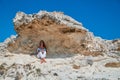 Dreamy woman sitting in shade under rock. Contemplation or Peace of mind idea. Feeling of calm orTime to rest idea.