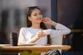 Dreamy woman sitting on the terrace of the cafe and drinking cappuccino Royalty Free Stock Photo