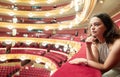 Dreamy woman sitting on balcony in theater hall during intermission Royalty Free Stock Photo