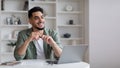 Dreamy Young Arab Man Sitting At Desk With Laptop In Home Office Royalty Free Stock Photo