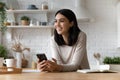 Dreamy young asian vietnamese woman holding cellphone. Royalty Free Stock Photo