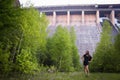 A dreamy young brunette girl stay near hydroelectric power station. Evening time. Side view Royalty Free Stock Photo