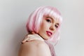 Dreamy young woman with bright makeup posing with pleasure in studio. Close-up photo of gorgeous female model in pink