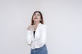 A dreamy young woman in deep thought looking up while holding a pen towards her chin. Isolated on a white background Royalty Free Stock Photo