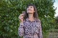 Dreamy young woman looking up, holding in hand, eating chocolate bar and thinking about something Royalty Free Stock Photo