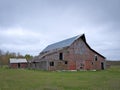 Dreary Abandoned Dilapidated Farm Barn with cloudy skies