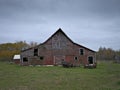 Dreary Abandoned Dilapidated Farm Barn with cloudy skies