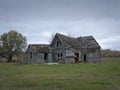 Dreary Abandoned Dilapidated Farm House with cloudy skies