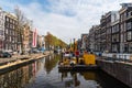 Dredger barge carrying out maintenance and cleaning of a canal in Amsterdam