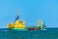 Dredger, a sea vessel sails through the sea and deepens the bottom, view of a large ship on a sunny summer day Royalty Free Stock Photo