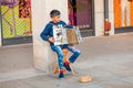 Street musician kid performing music for donating money and coins Royalty Free Stock Photo