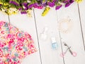 dress, colorful flowers, cosmetics makeup, bijou and essentials on white wooden background Royalty Free Stock Photo