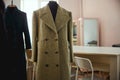 Dress stand with brown tweed coat near table Royalty Free Stock Photo