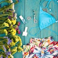 dress, swimsuit, cosmetics makeup, bijou and essentials on blue wooden background