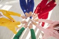 Dressed in colorful fashionable business suits team joins hands to create circle concept of unity and teamwork. Team in