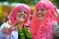 Dressed to the nines. Portrait of two young women dressed up in wigs at an outdoor festival. Royalty Free Stock Photo